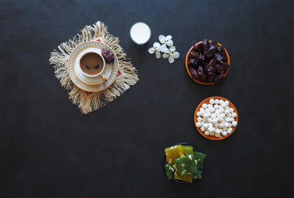 Zwarte koffie, melk, datums en Turkse zoetigheden op een zwarte achtergrond. Zoet voedsel voor Ramadan — Stockfoto