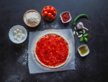 Üretim İtalyan Pizza Margarita. Üretim aşaması. Domates sosu, mozzarella peyniri ve domates.