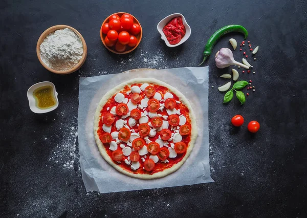 Produção de pizza italiana Margarita. Estágio de produção. Molho de tomate, queijo mussarela e tomate . — Fotografia de Stock