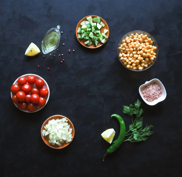 Vegetarische Sommerkost. Salat mit Kichererbsen und Gemüse auf einem schwarzen Tisch. — Stockfoto