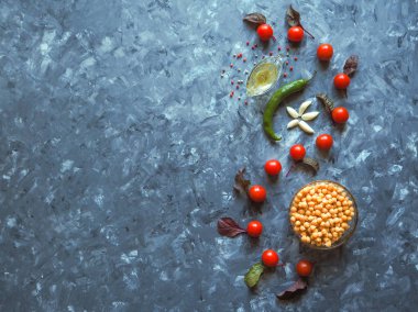 Nohut ve kiraz domates ile üstten görünüm ve boşaltmak gri mutfak masasında