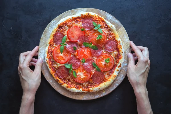 Pizza de pepperoni caseira em uma mesa preta . — Fotografia de Stock