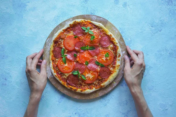 Pizza de pepperoni caseira em uma mesa de cozinha azul. Vista superior — Fotografia de Stock