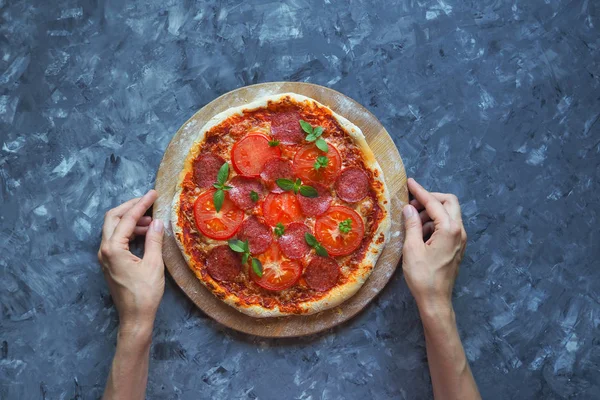 Pizza de pepperoni caseira em uma mesa de cozinha azul-cinza. Vista superior — Fotografia de Stock