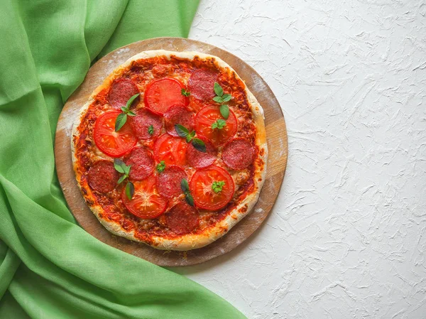 W domu pepperoni pizza na stół kuchenny biały. — Zdjęcie stockowe