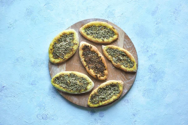 Scones with Zatar. Manakish Arabic on a wooden tray. Arabic cuisine.