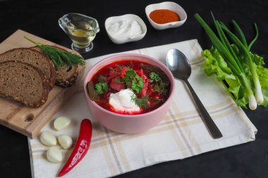 Geleneksel Ukraynalı Rus Pancar çorbası fasulye kupa ile. Kırmızı pancar kök çorbası borsch siyah masada tabak.