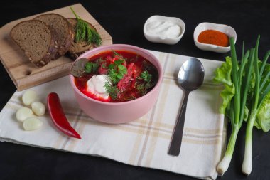 Geleneksel Ukraynalı Rus Pancar çorbası fasulye kupa ile. Kırmızı pancar kök çorbası borsch siyah masada tabak.