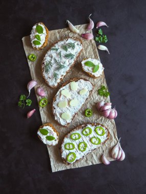 Siyah masada krema bulaşmış sarımsaklı ekmek. Sarımsak soslu meze.