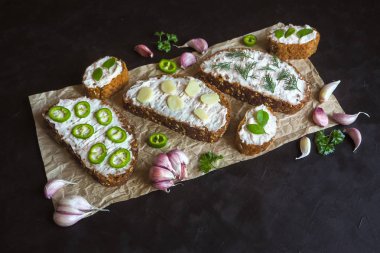 Siyah masada krema bulaşmış sarımsaklı ekmek. Sarımsak soslu meze.