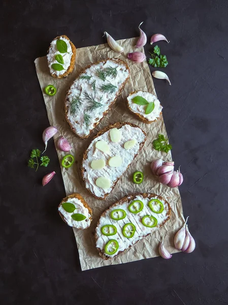 Siyah masada krema bulaşmış sarımsaklı ekmek. Sarımsak soslu meze.