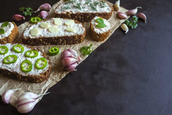 Siyah masada krema bulaşmış sarımsaklı ekmek. Sarımsak soslu meze.