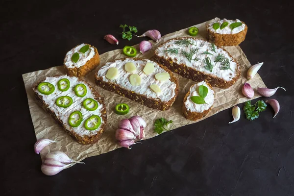 Siyah masada krema bulaşmış sarımsaklı ekmek. Sarımsak soslu meze.