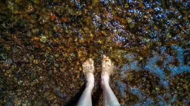 Karanlık su ayaklarda yaklaşan dalganın.