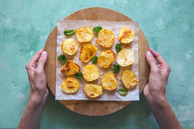 İştah açıcı fırında patates yarım parşömen üzerine.