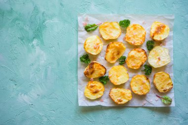 İştah açıcı fırında patates yarım parşömen üzerine.