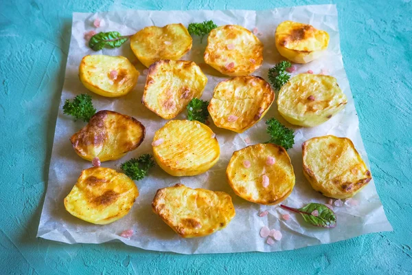 İştah açıcı fırında patates yarım parşömen üzerine.