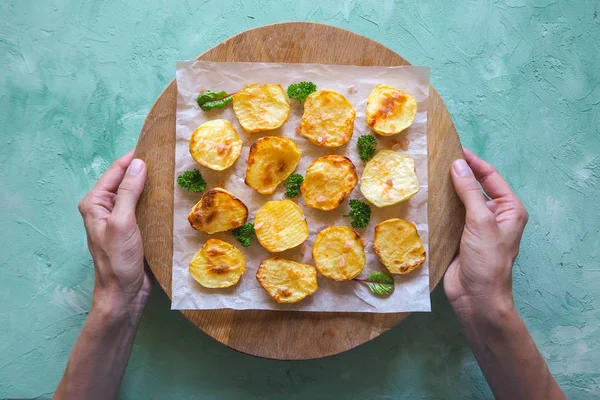 İştah açıcı fırında patates yarım parşömen üzerine.