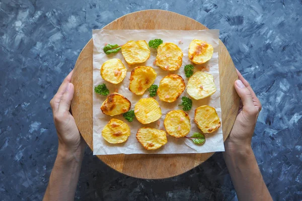 İştah açıcı fırında patates yarım parşömen üzerine.