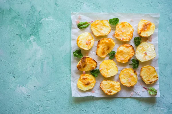 İştah açıcı fırında patates yarım parşömen üzerine.