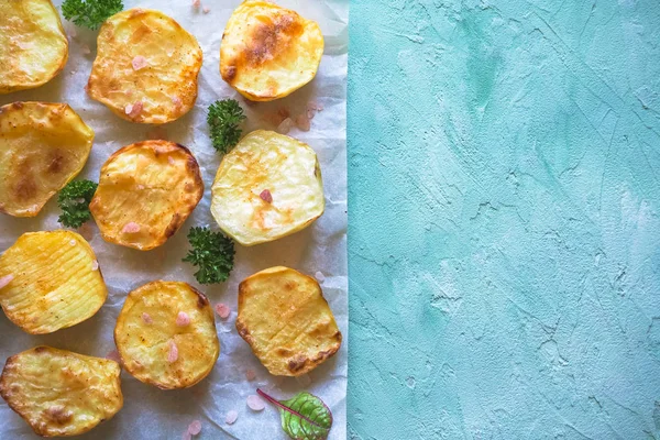 İştah açıcı fırında patates yarım parşömen üzerine.