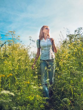 Kadın alpin çayır güneşli gün seyir sırt çantası ile seyahat.