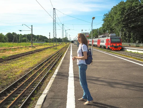 Dame voyageur avec sac à dos sur la plate-forme ferroviaire dans une petite ville européenne . — Photo