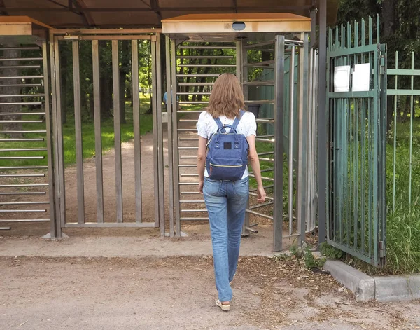 Turnstile, entrada restrita. Uma senhora viaja através de uma catraca para um parque privado . — Fotografia de Stock