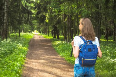 Bayan sırt çantası ile seyahat ormanda.