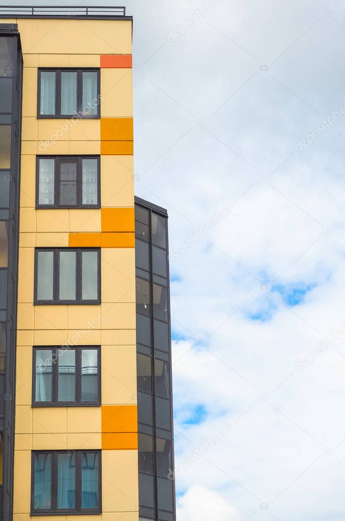 Modern beautiful new buildings. Colored wall on the background of blue sky.