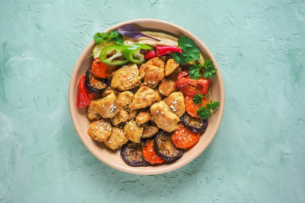 Bir plaka üzerinde ızgara sebzeli fırında et parçaları