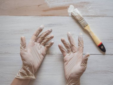 Resim çalışmalarına onarın. Ellerinde boya fırçası ve boyalı kat sonuna kadar arka plan üzerinde beyaz eldiven