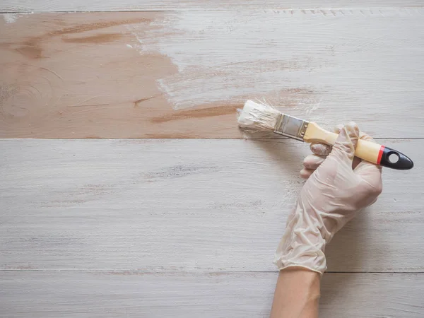 Trabajos de reparación de pintura. Pintura pincel en su mano pinta el suelo . — Foto de Stock