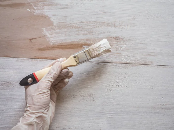 Trabajos de reparación de pintura. Pintura pincel en su mano pinta el suelo . — Foto de Stock