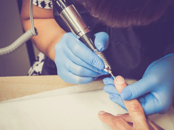 Hardware manicure in de Aziatische salon. Een oude dame doet een manicure. — Stockfoto