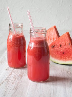 taze sıkılmış karpuz suyu şişelerde bir beyaz ahşap tablo