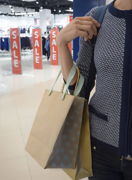 Sale of clothes. Shopping bags in a woman\'s hand.