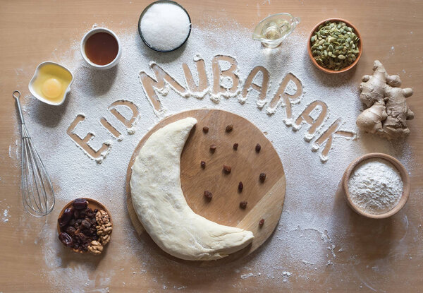 Eid Mubarak - Islamic holiday welcome phrase " happy holiday", greeting reserved. Arabic cuisine background. Stock Photo