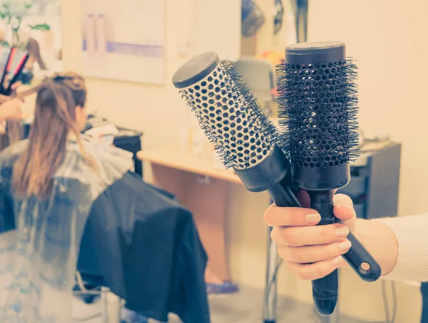 Hair salon háttér. Fésű a kezében, a háttérben egy homályos fodrászat. — Stock Fotó