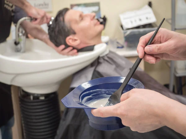 Un hombre se pinta el pelo en una peluquería. Tecnologías innovadoras de restauración del cabello para hombres . — Foto de Stock