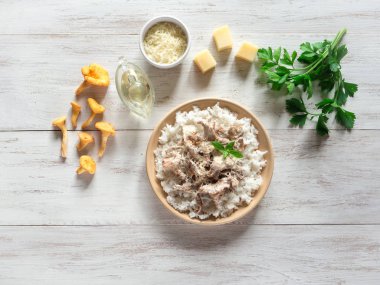 Mantar chanterelles ahşap beyaz masa üzerinde bir tabakta risotto.