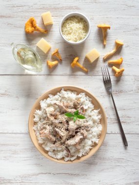 Mantar chanterelles ahşap beyaz masa üzerinde bir tabakta risotto.