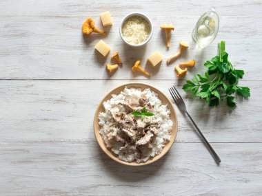 Ahşap antika masa üzerinde bej porselen tabakta Cantharellus cibarius risotto