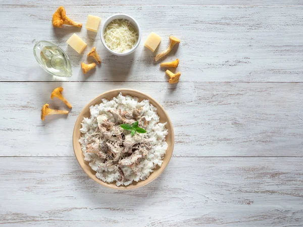 Ahşap antika masa üzerinde bej porselen tabakta Cantharellus cibarius risotto