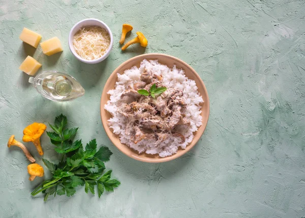 Fıstıklı bir beton tabloda bej porselen tabakta chanterelles risotto