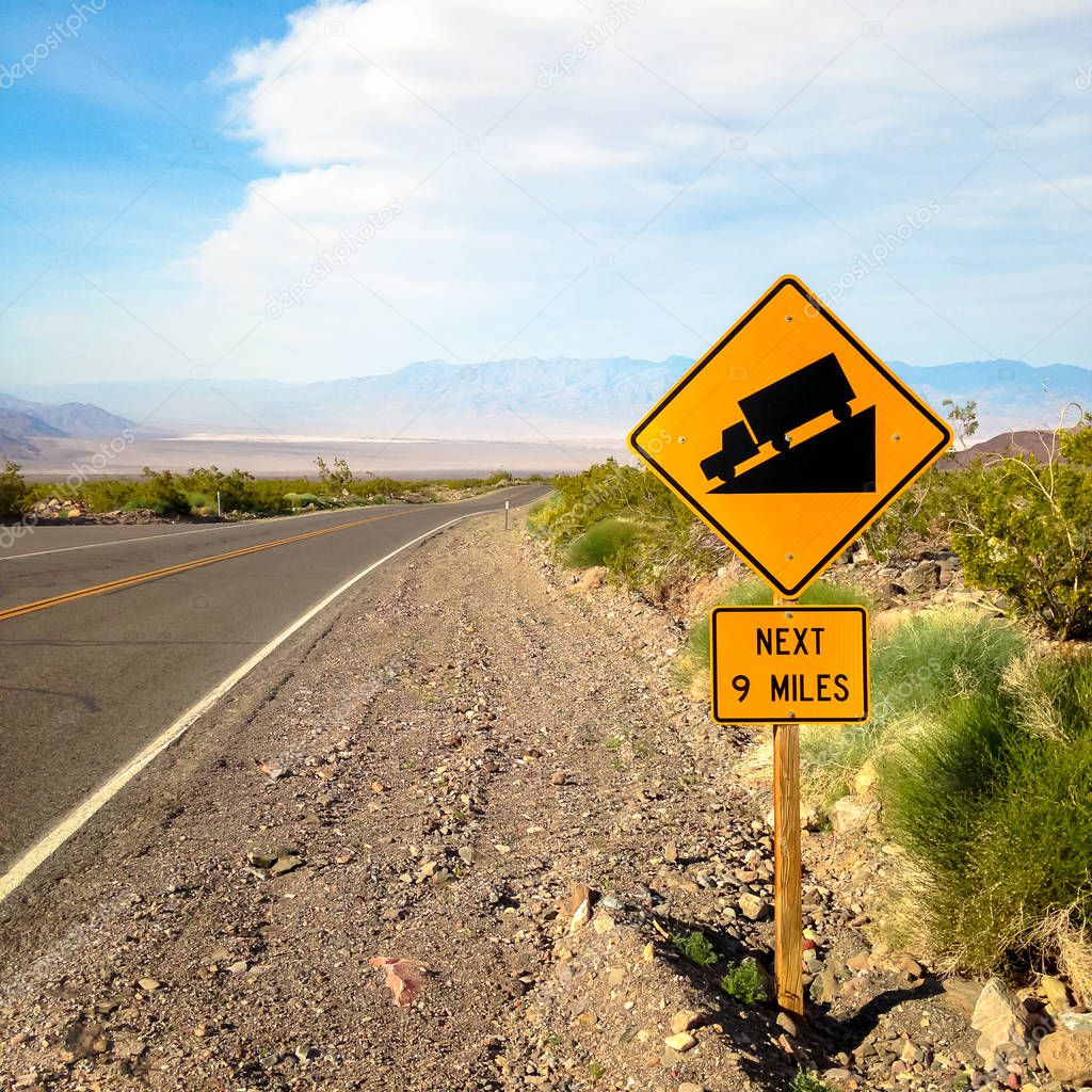 USA. Death valley. Sign at the road steep descent.