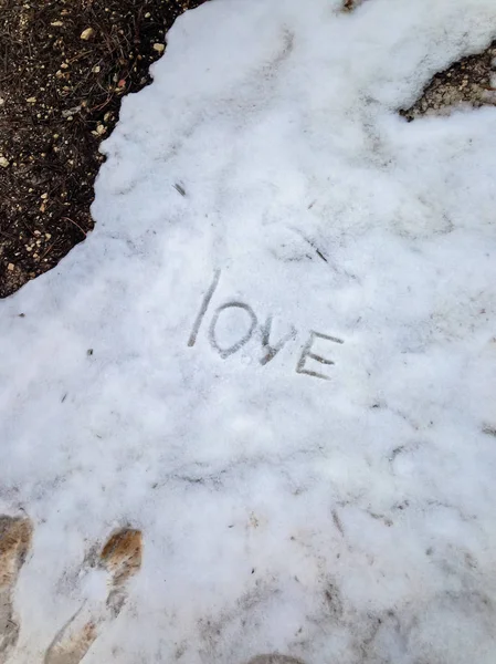 Inscrição Amor na neve derretida na primavera . — Fotografia de Stock