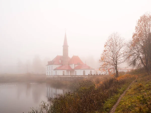 Осенний пейзаж со старым замком в тумане . — стоковое фото