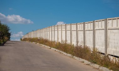 Bir Beton çit perspektif. Mavi gökyüzüne karşı Beton çit.