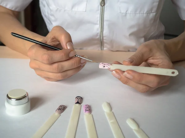 Diseño de uñas. Mujer maestro dibuja en consejos . — Foto de Stock